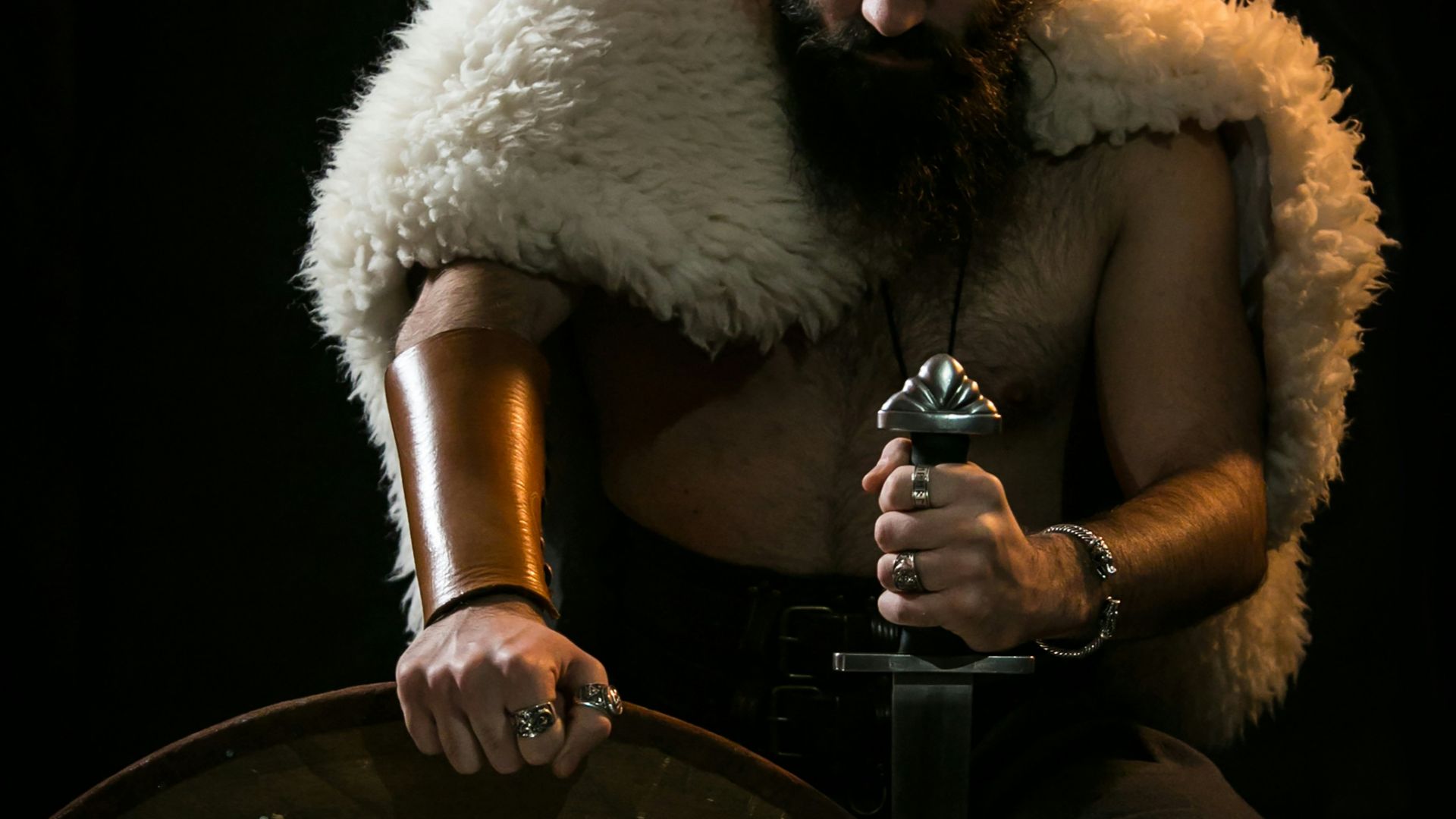 man in black pants sitting on chair holding bottle