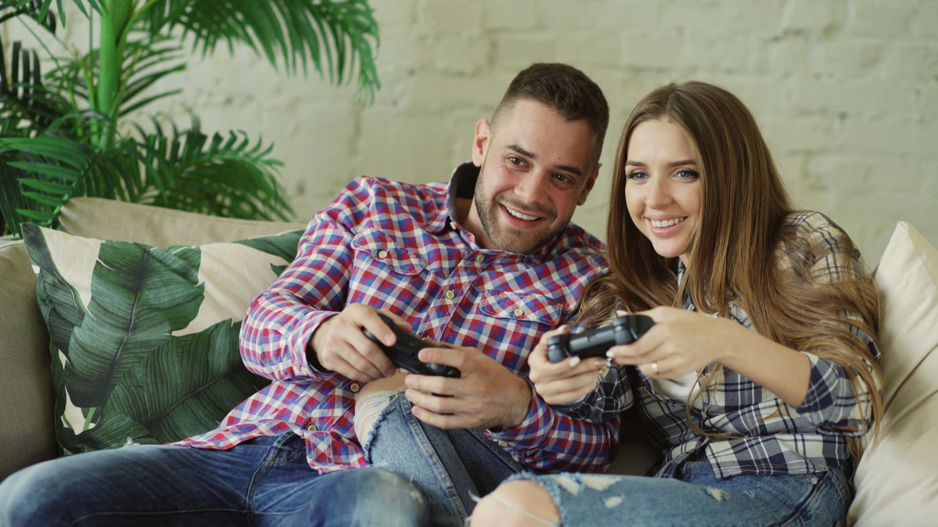 Couple playing video games together on couch