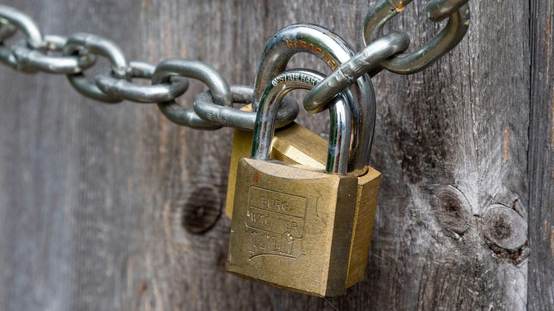 brown padlock on brown wooden fence