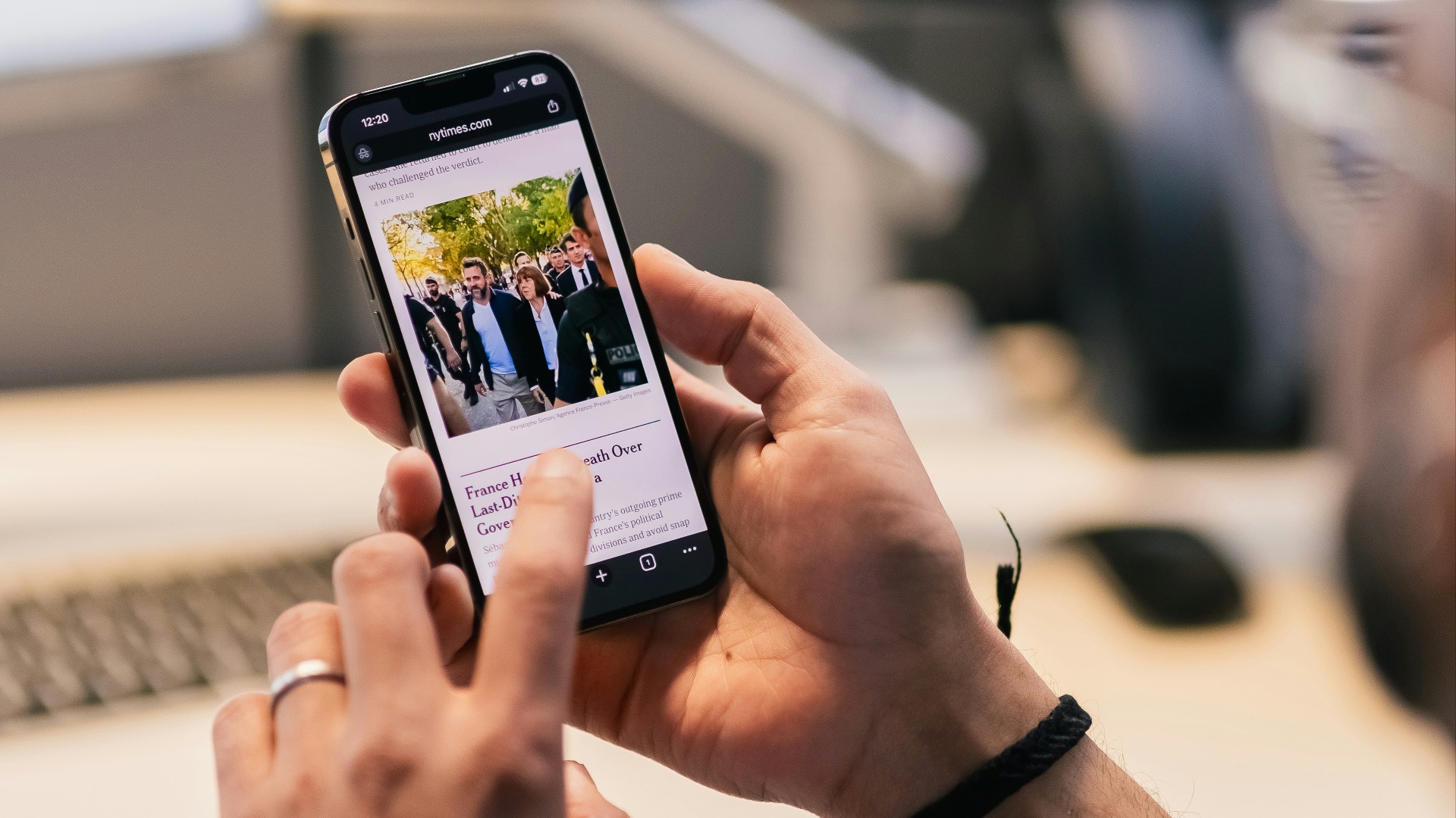 Person using smartphone with news article displayed