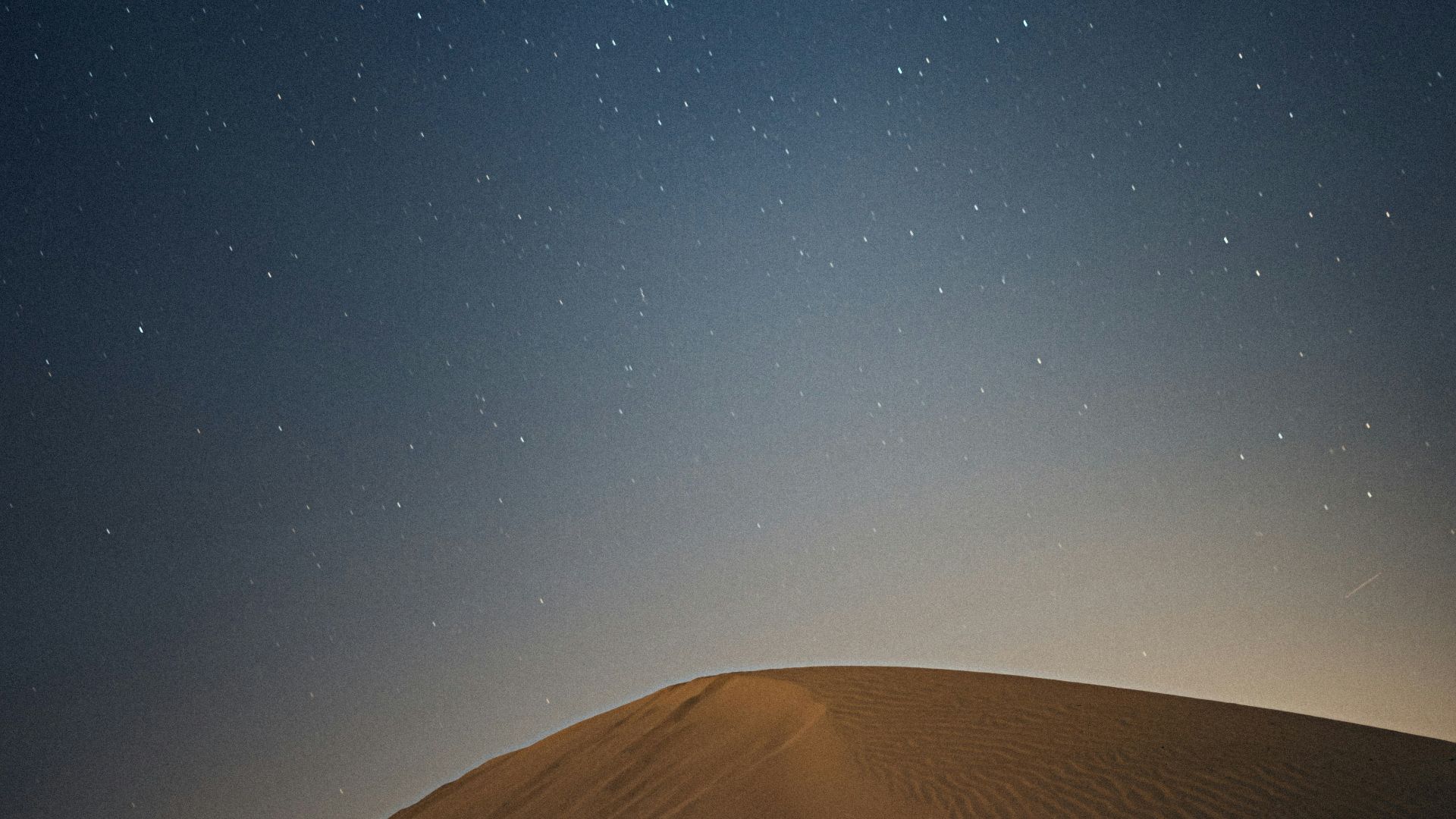 brown sand under blue sky during night time