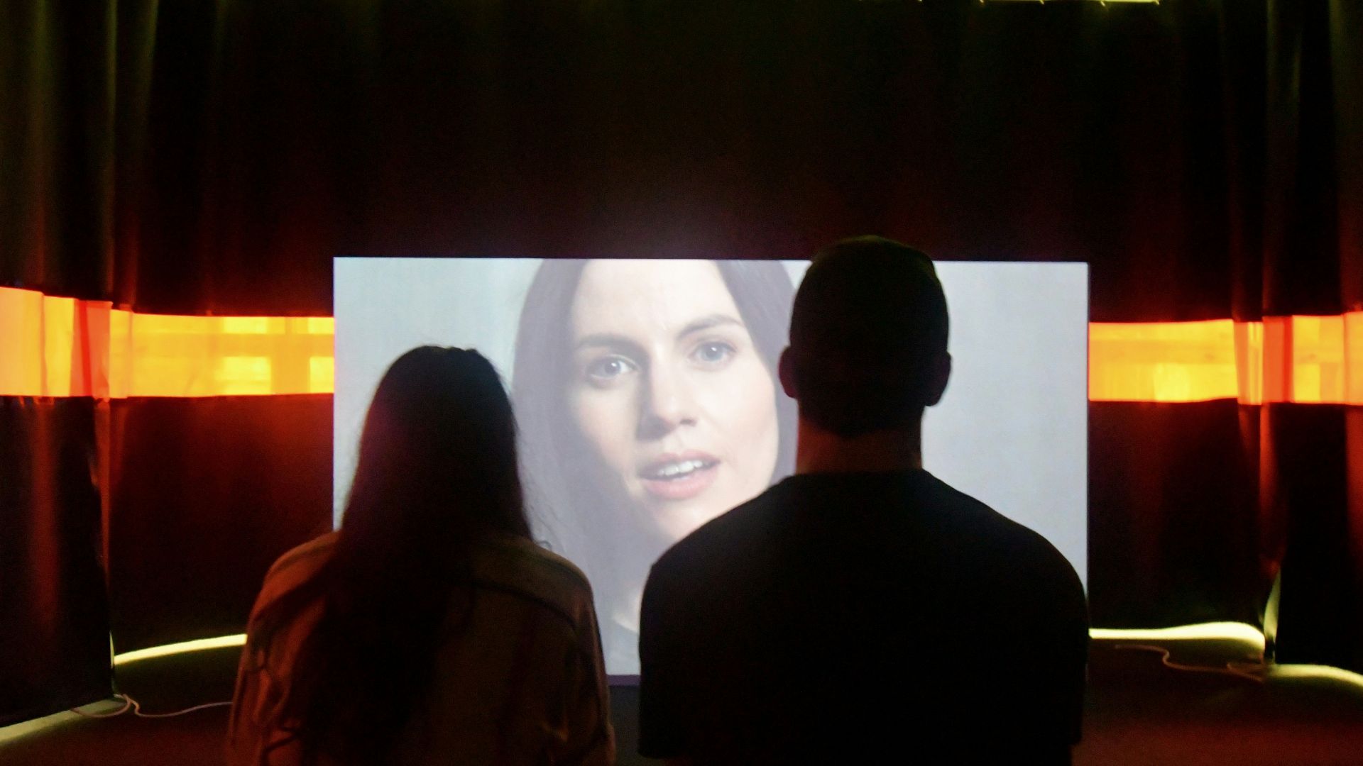 man in black shirt standing beside woman in brown coat