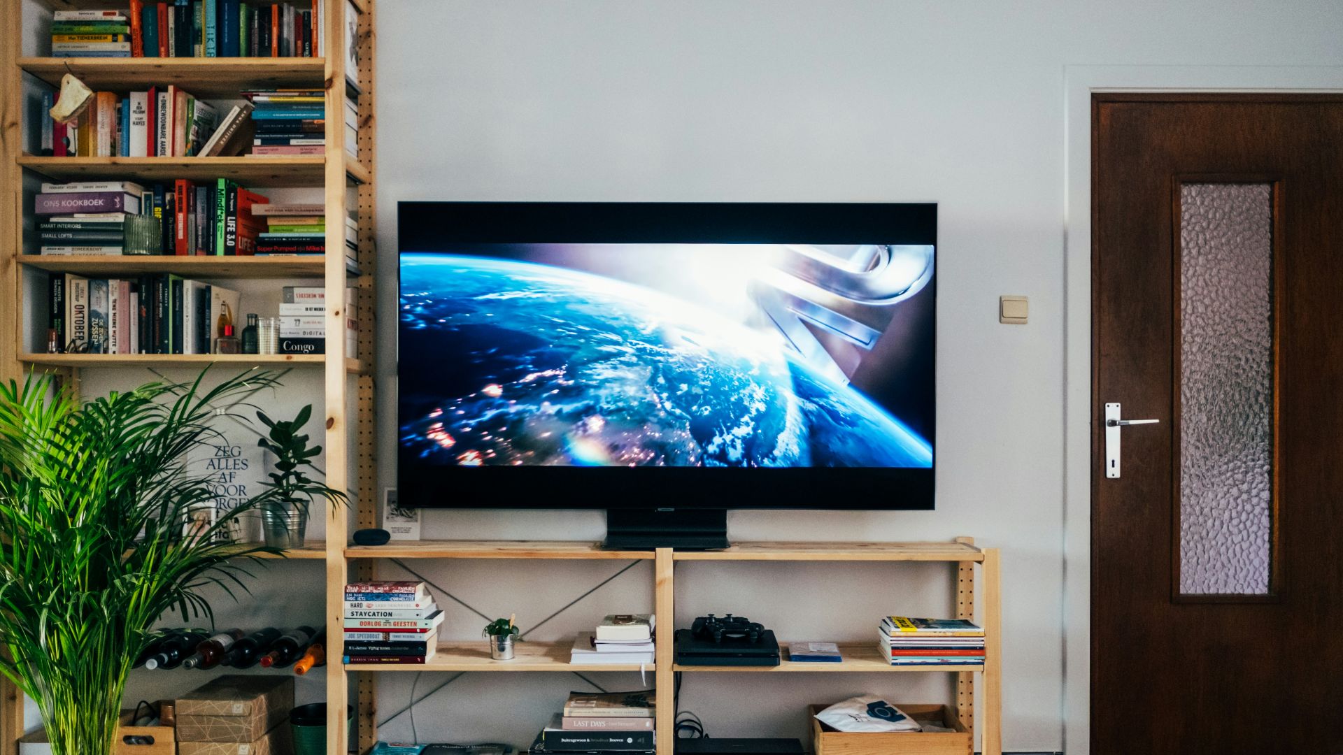 black flat screen tv turned on near brown wooden shelf