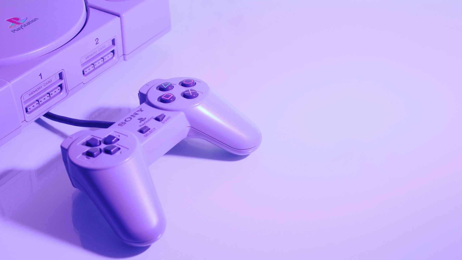 gray Sony PlayStation console with corded controller