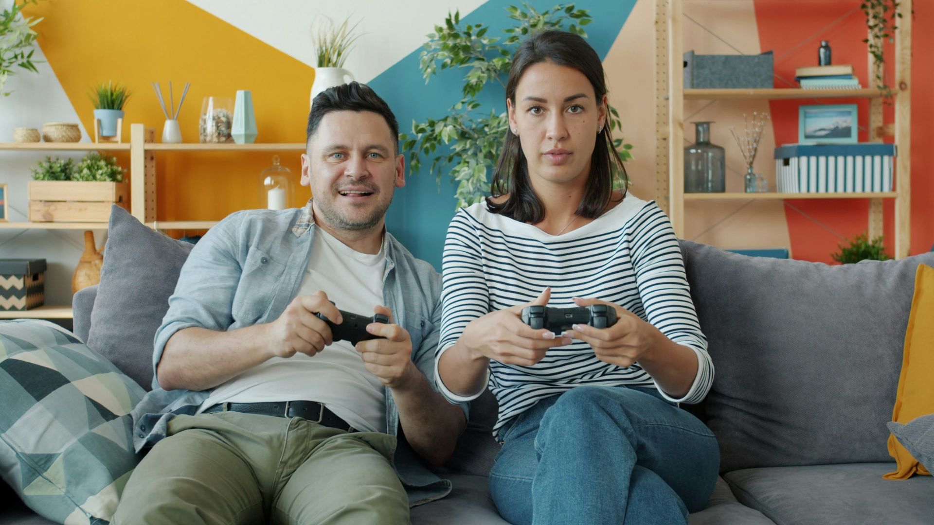 Couple playing video games on sofa