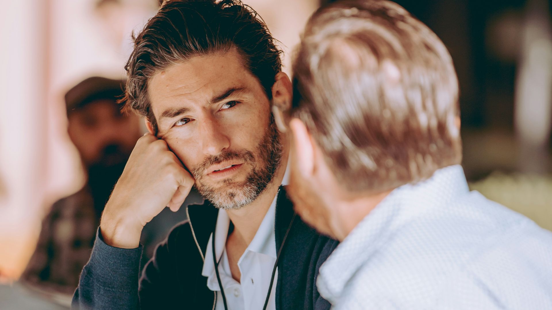 two men sitting at a table talking to each other