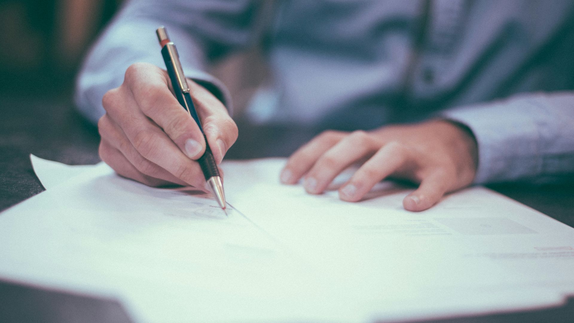 man writing on paper