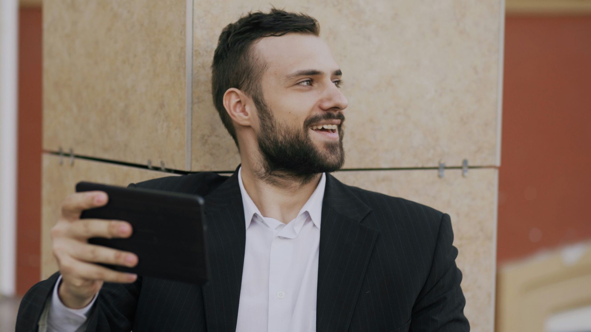 Man in suit taking a selfie with tablet