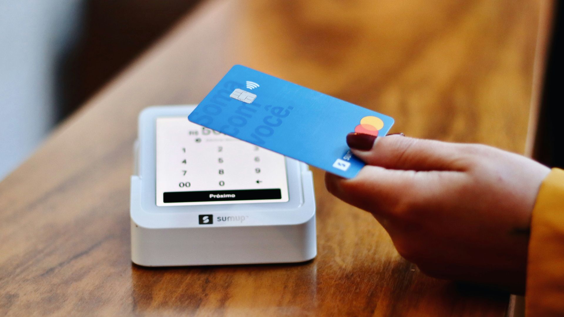 a person holding a credit card in front of a machine