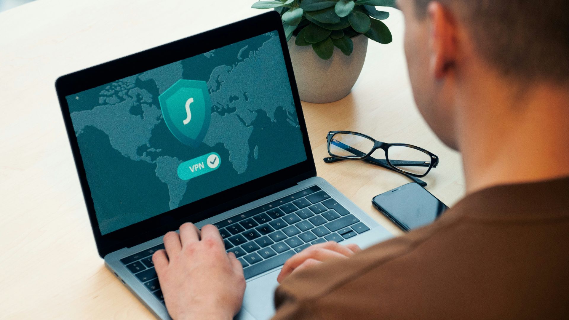 person using macbook pro on white table