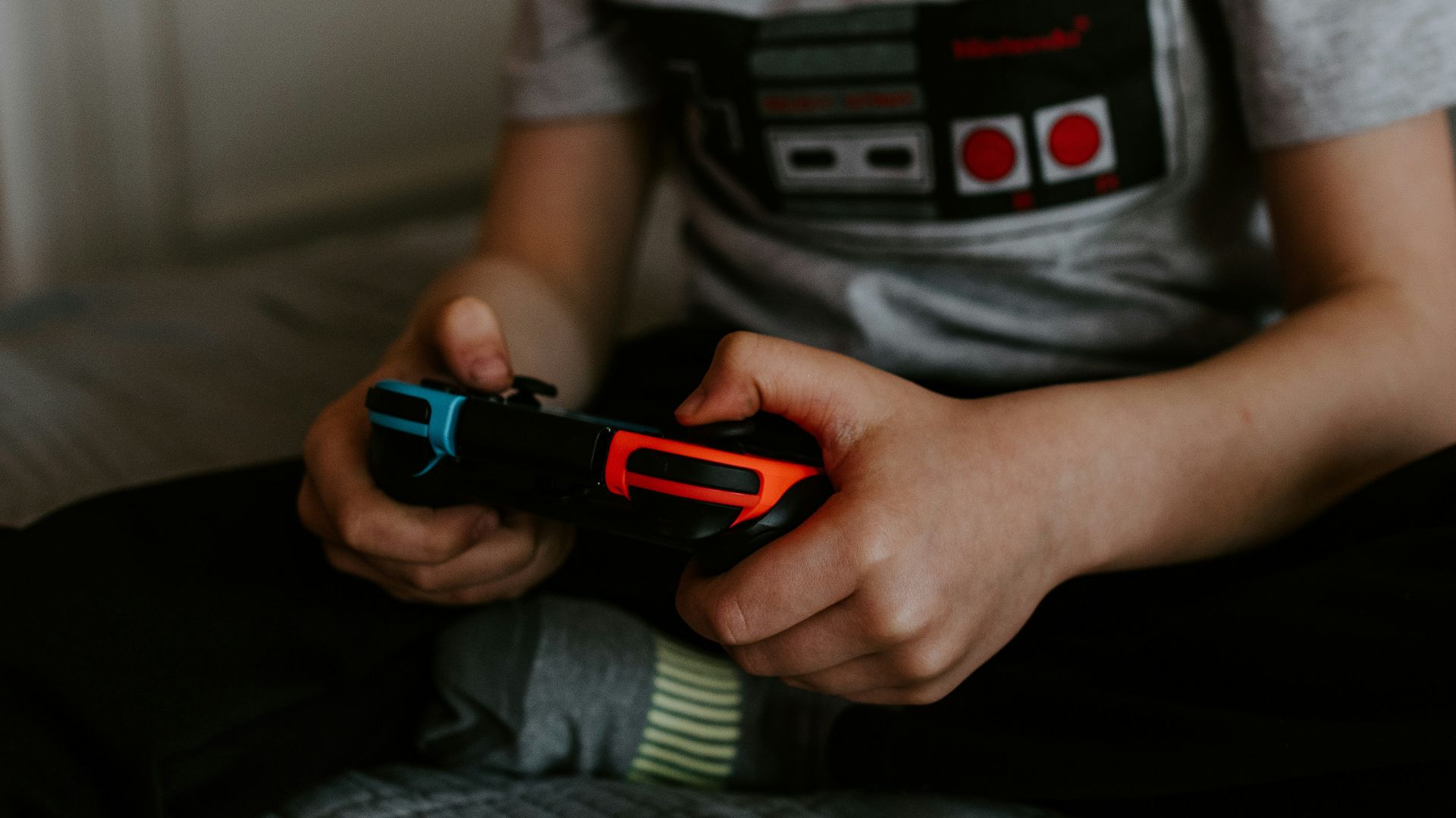 kid sitting on gray bed while playing