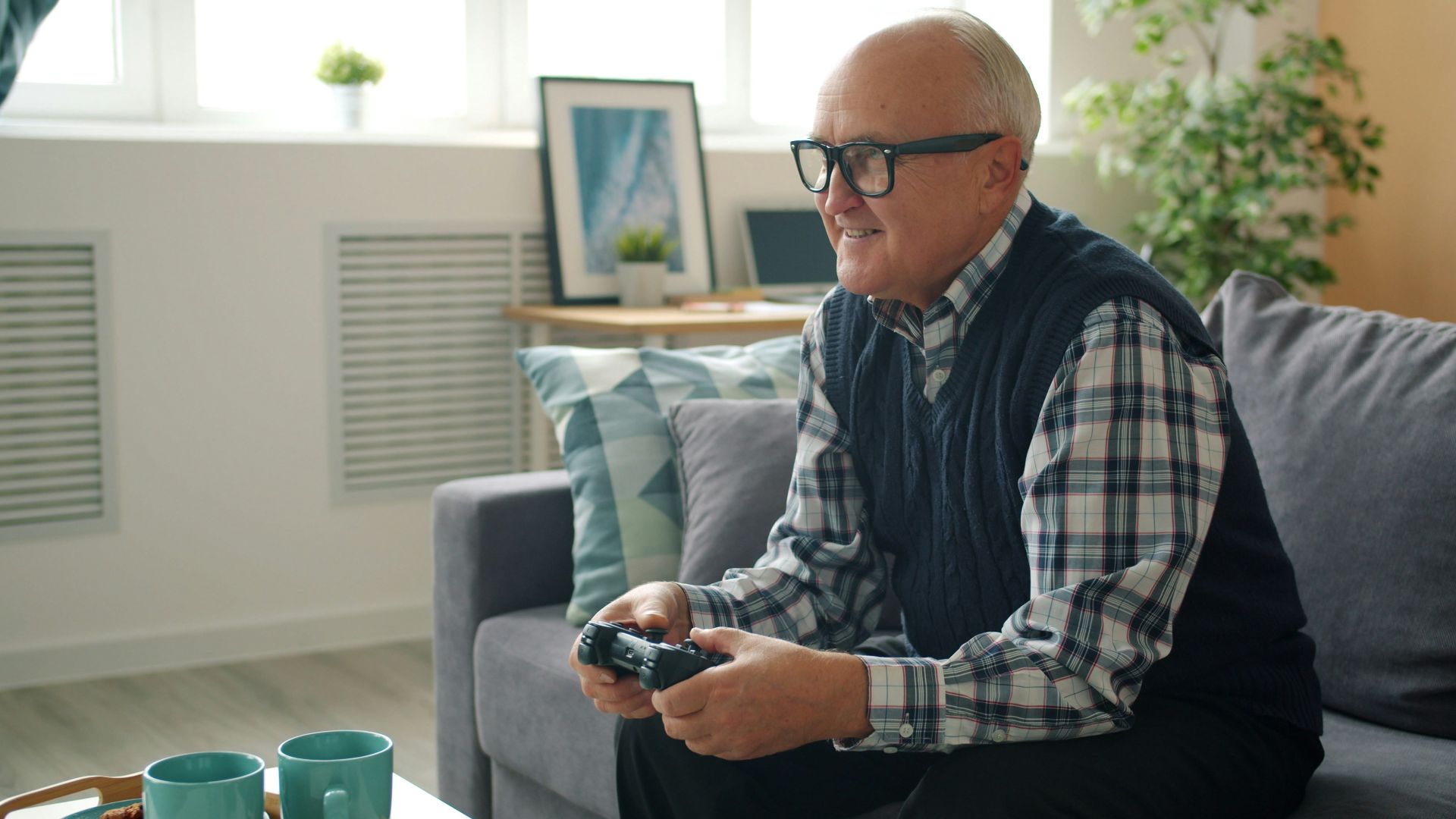 Elderly man playing video games on couch