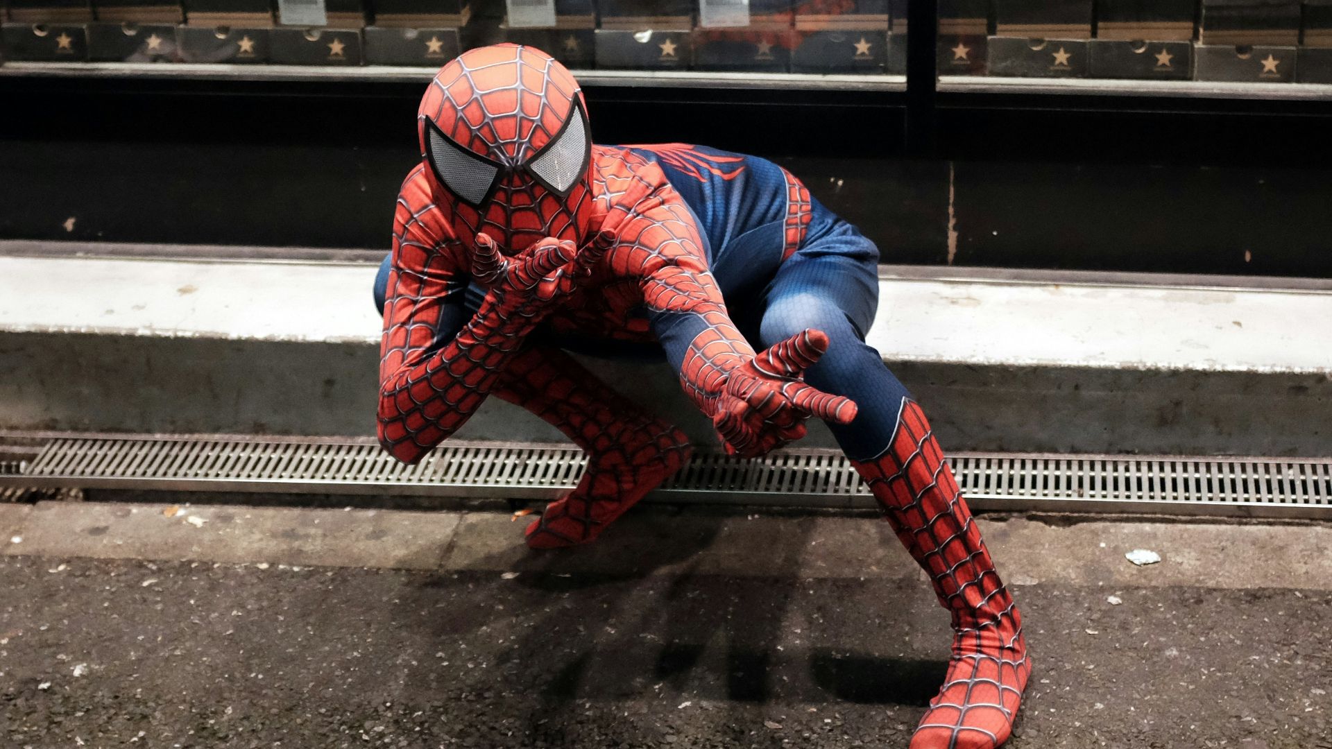 a man dressed as a spiderman crouching down