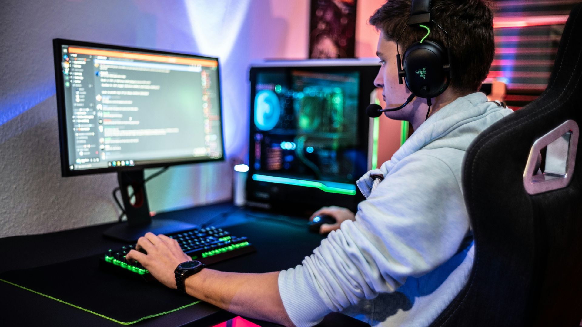 a man sitting at a computer with headphones on