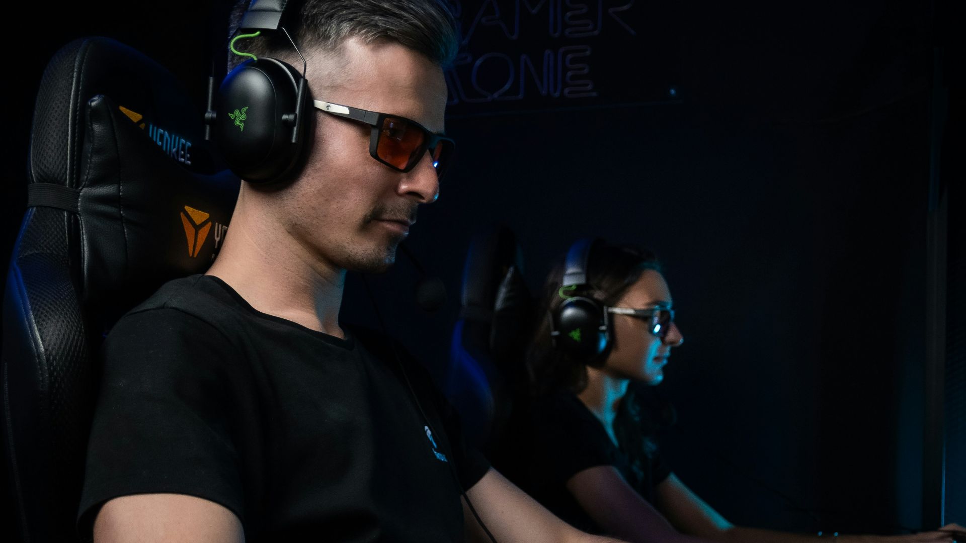 Two people playing video games with headphones on.