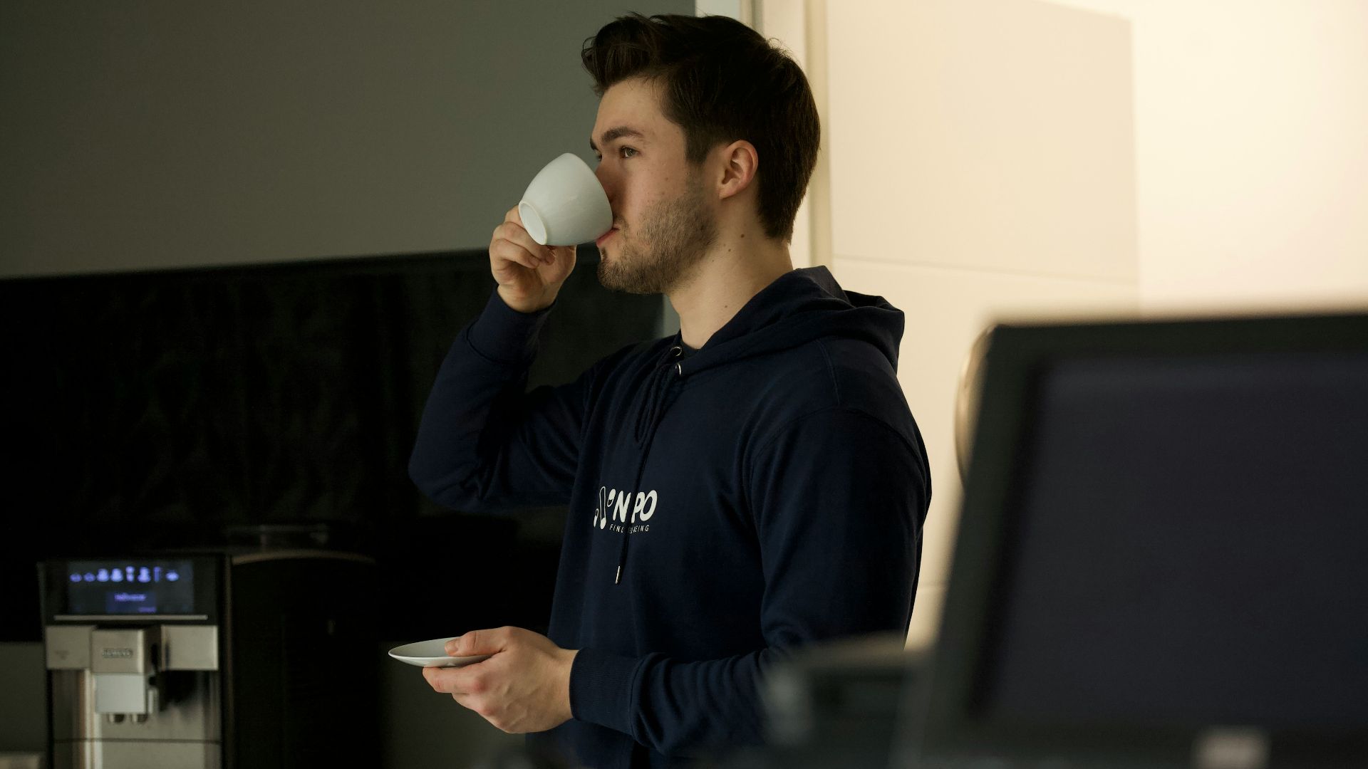 man in black nike crew neck shirt holding white ceramic mug