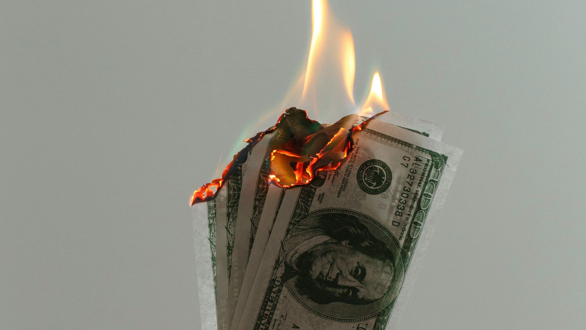 time lapse photography of several burning US dollar banknotes