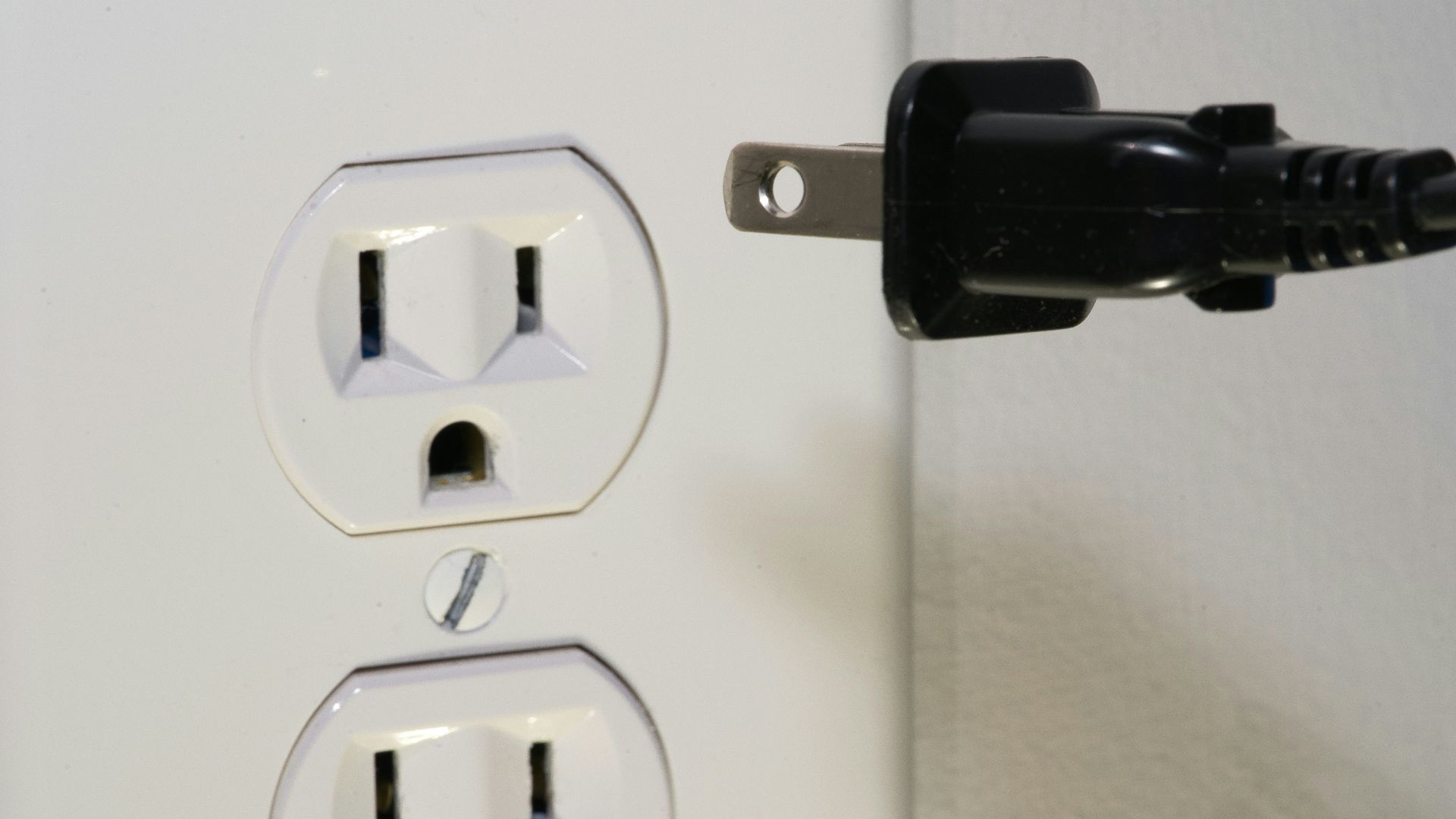 black male plug in front of electric socket