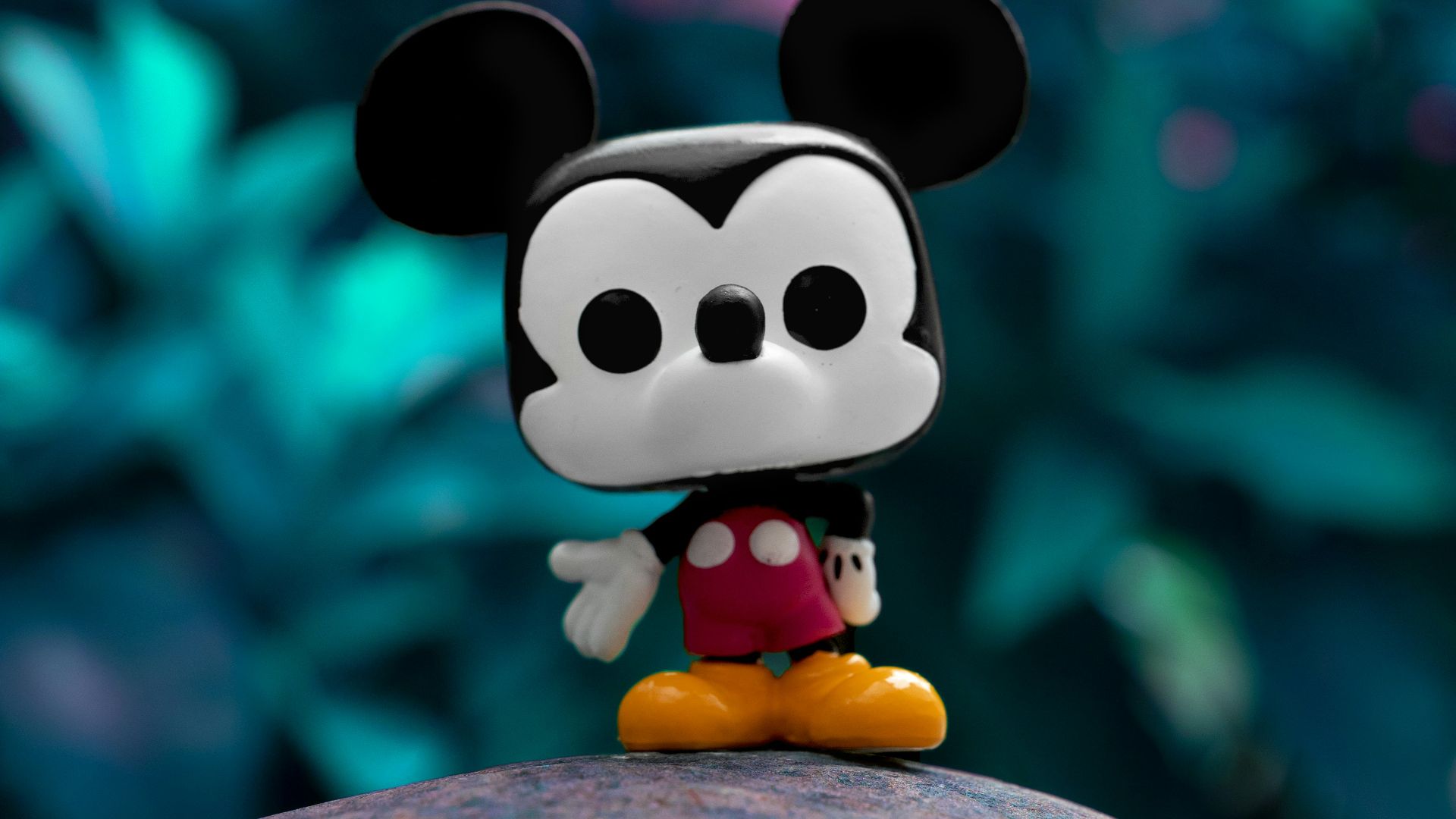 mickey mouse plush toy on gray rock