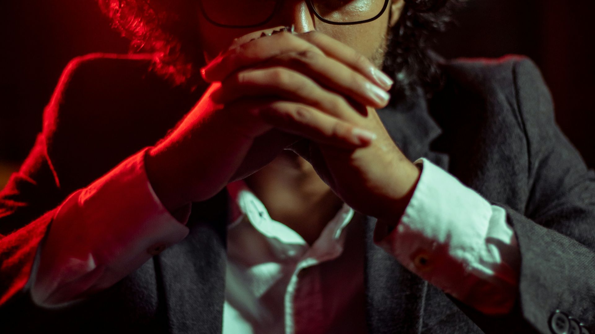man in black suit jacket wearing red hat