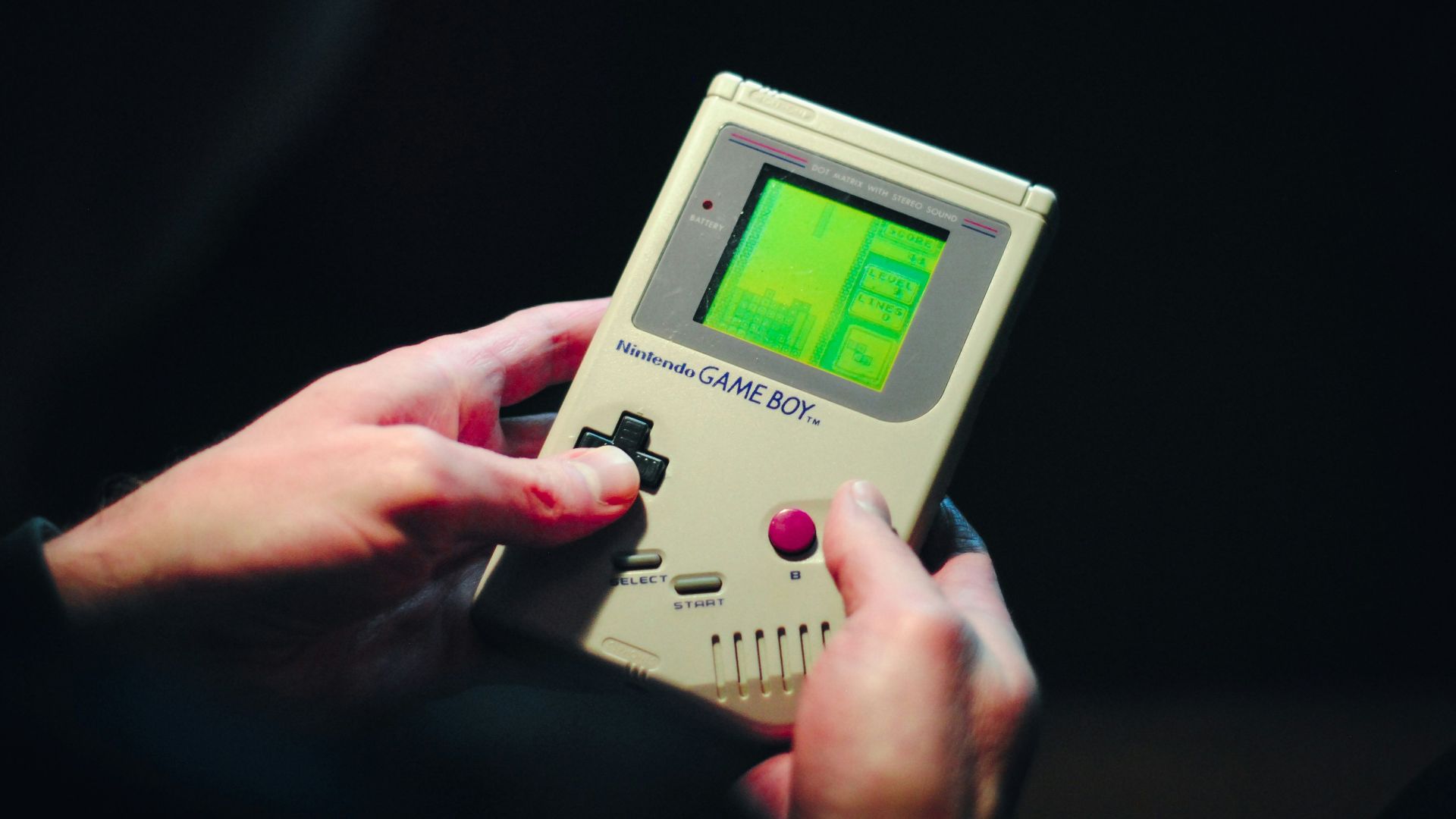 person holding gray nintendo game boy