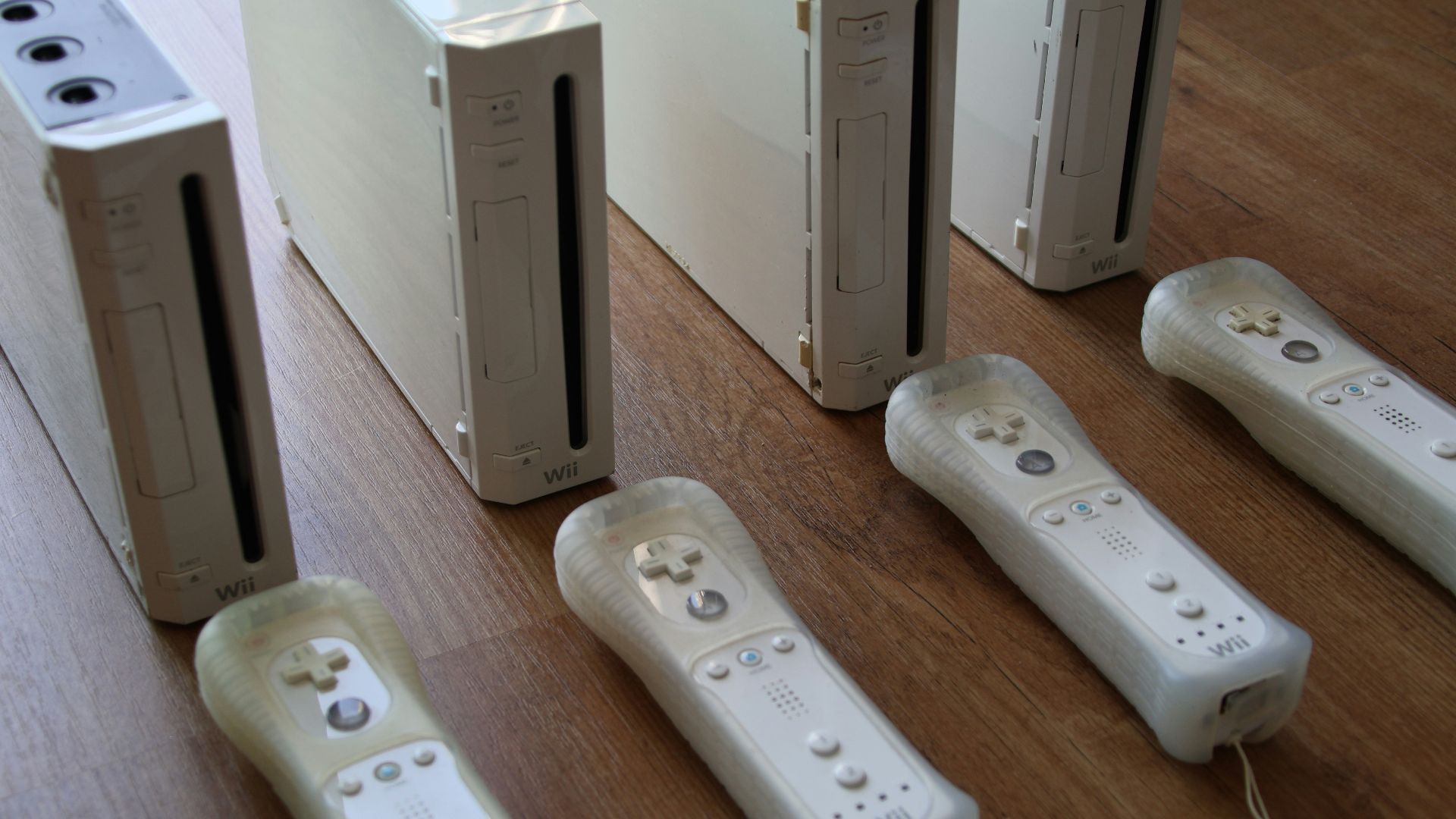 a group of video game controllers sitting on top of a wooden floor