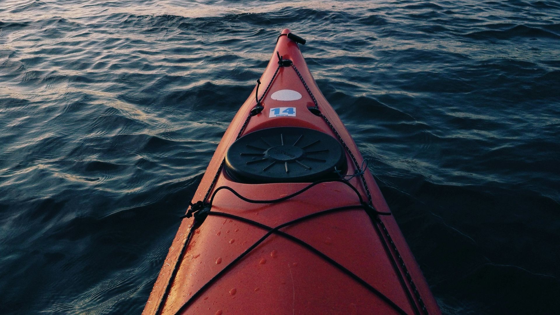 red canoe in body of water during daytime