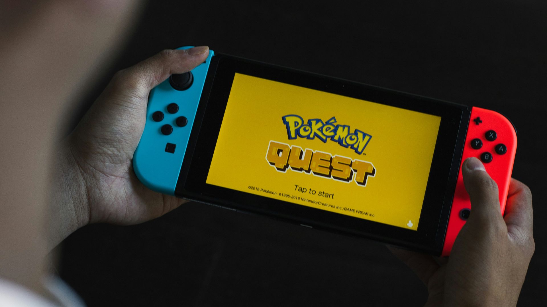 person holding yellow and blue box