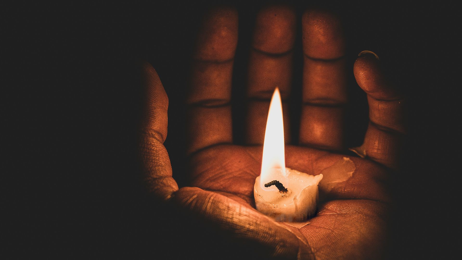 lit candle in hand