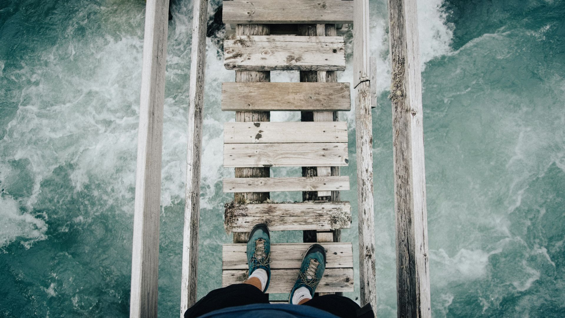 person standing on wooden bridge