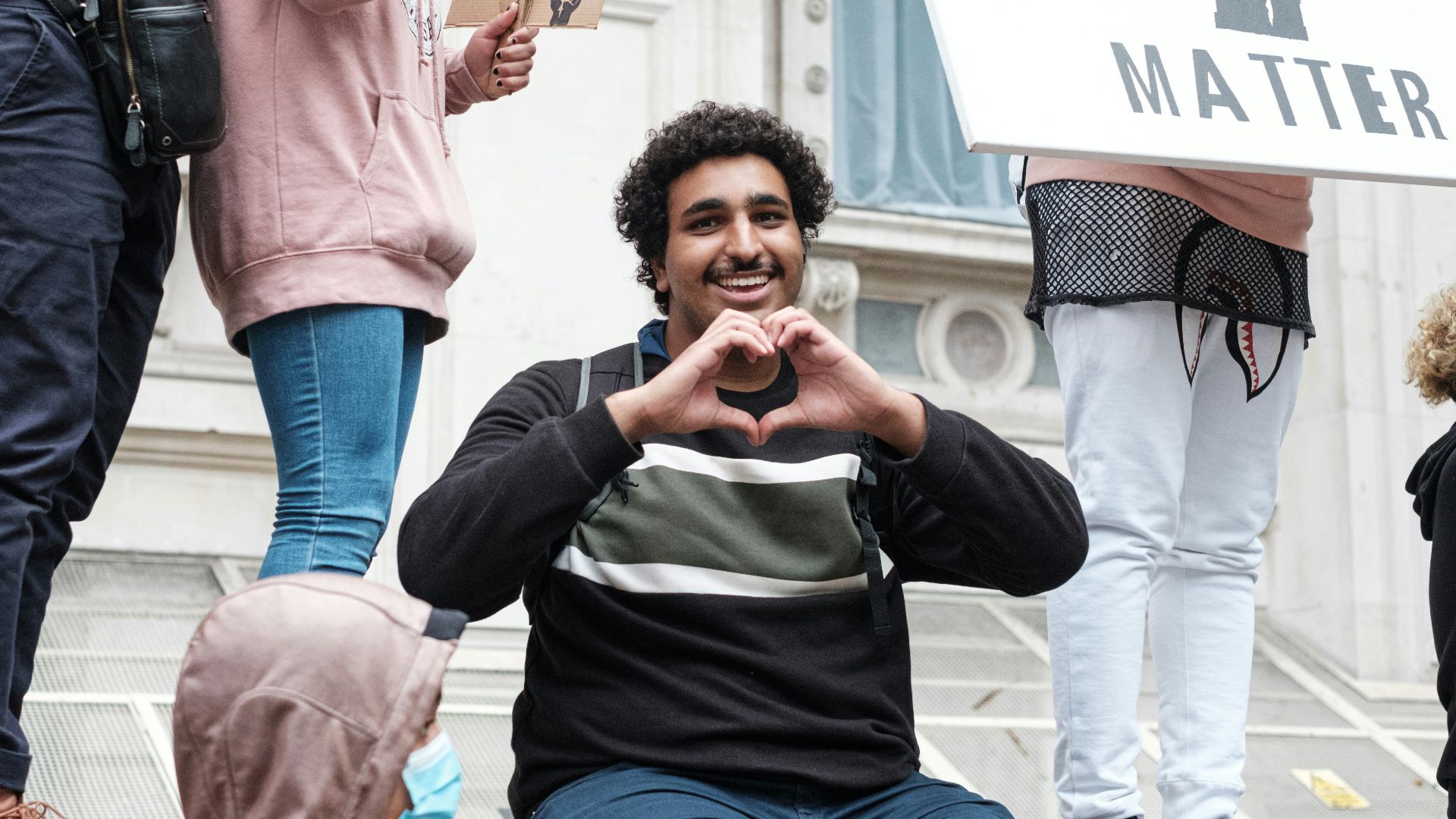 woman in black and white long sleeve shirt and blue denim jeans holding smartphone