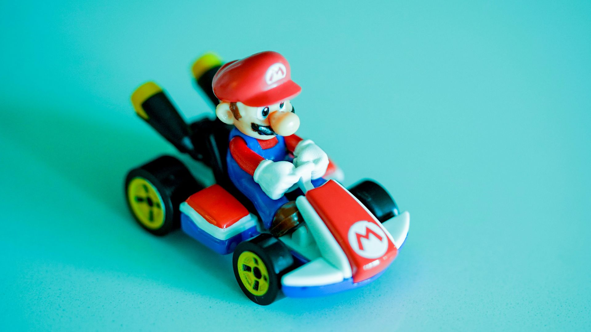 red haired man riding red and blue car plastic toy