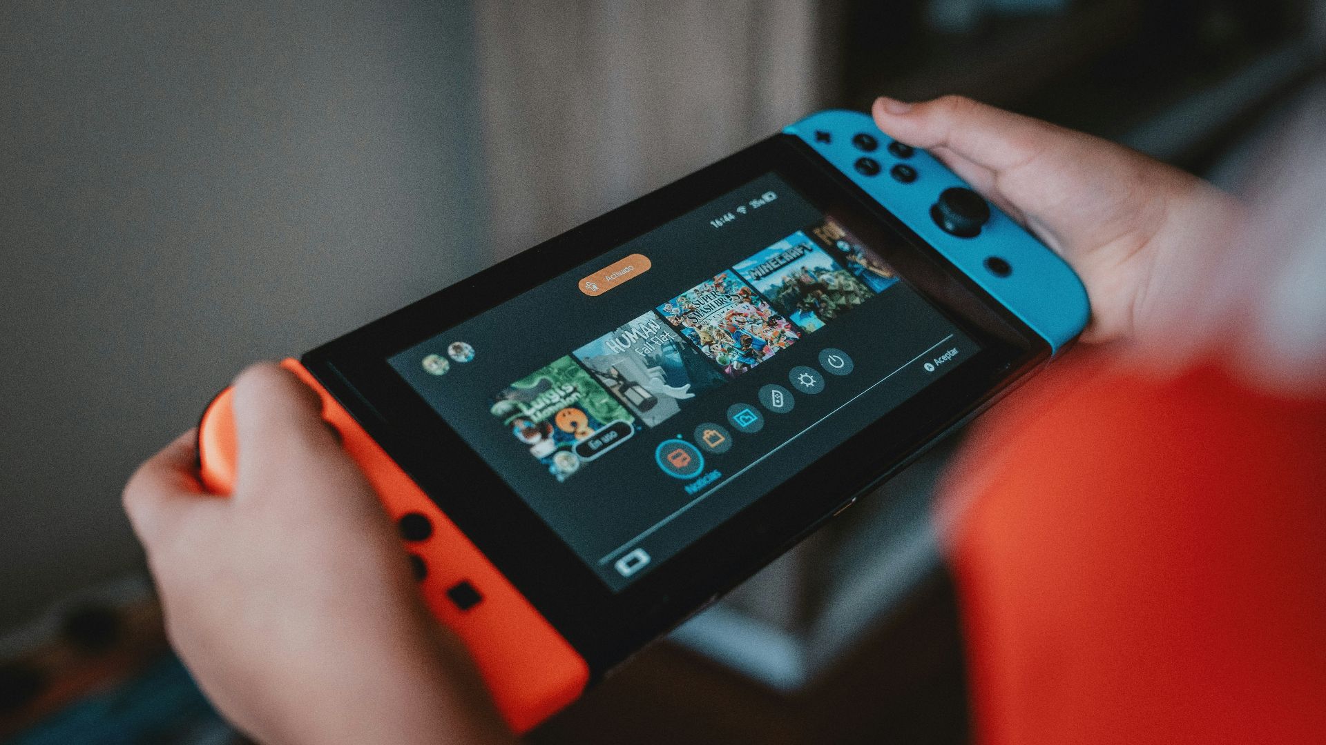 person holding black and orange nintendo switch