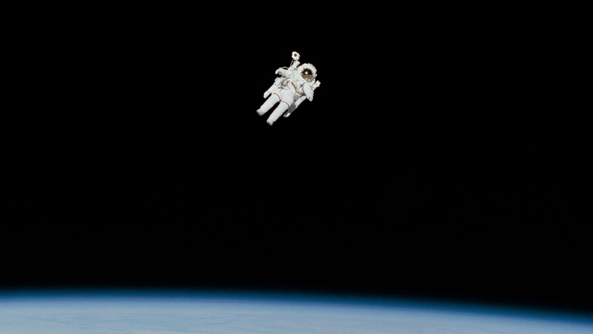 astronaut in spacesuit floating in space