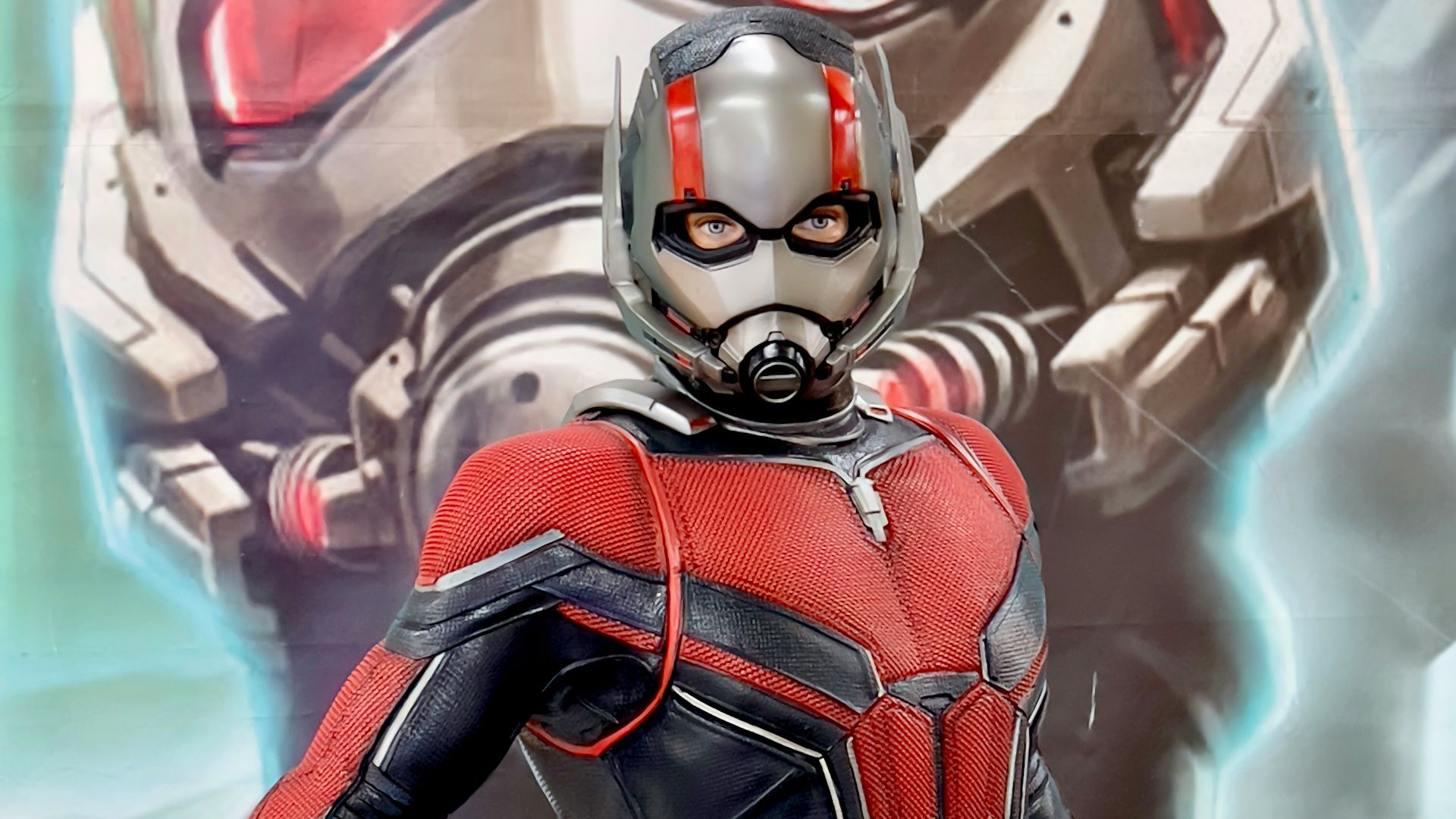 a man in a red and black suit standing next to a giant robot