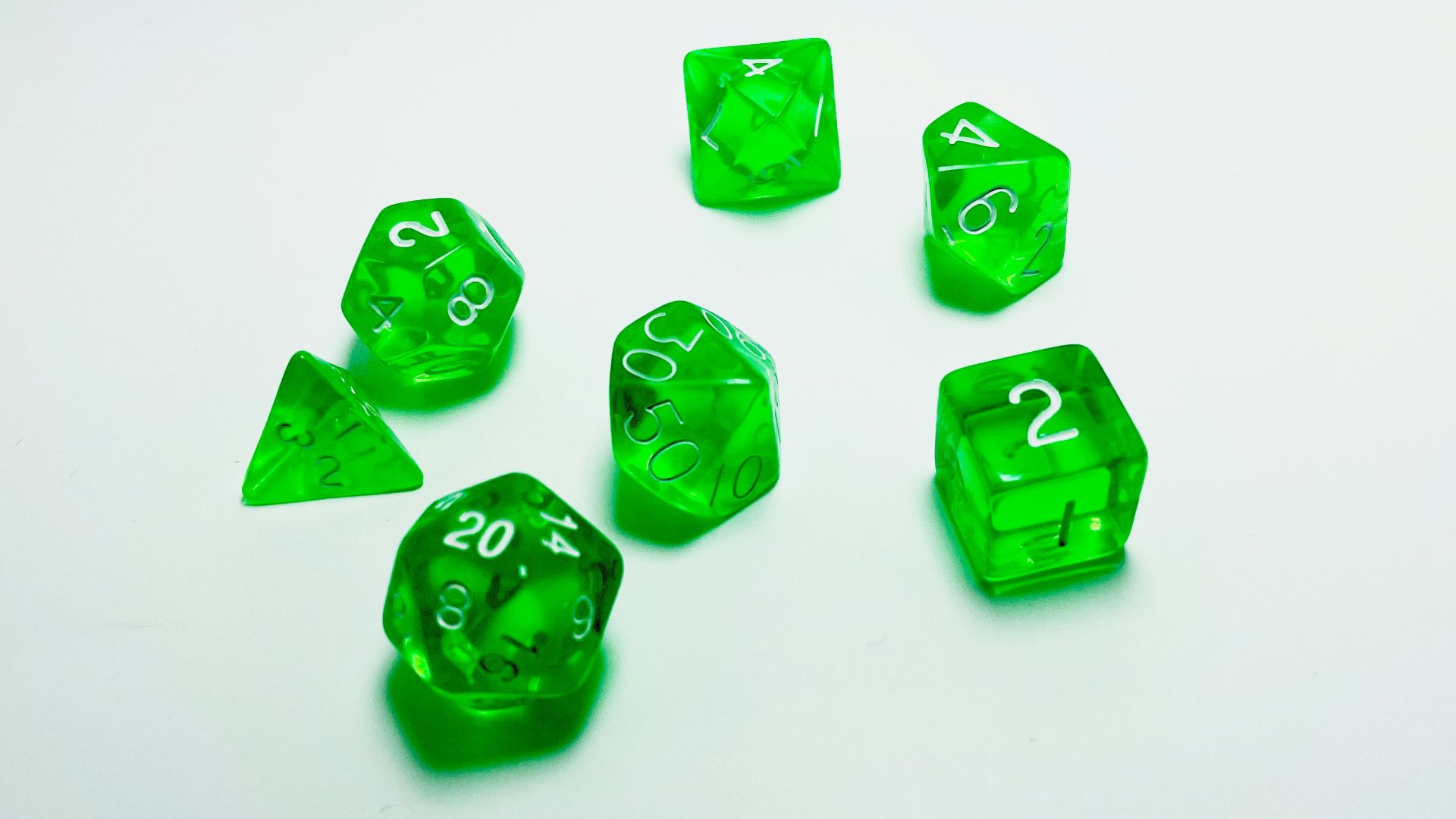 green plastic dice on white surface