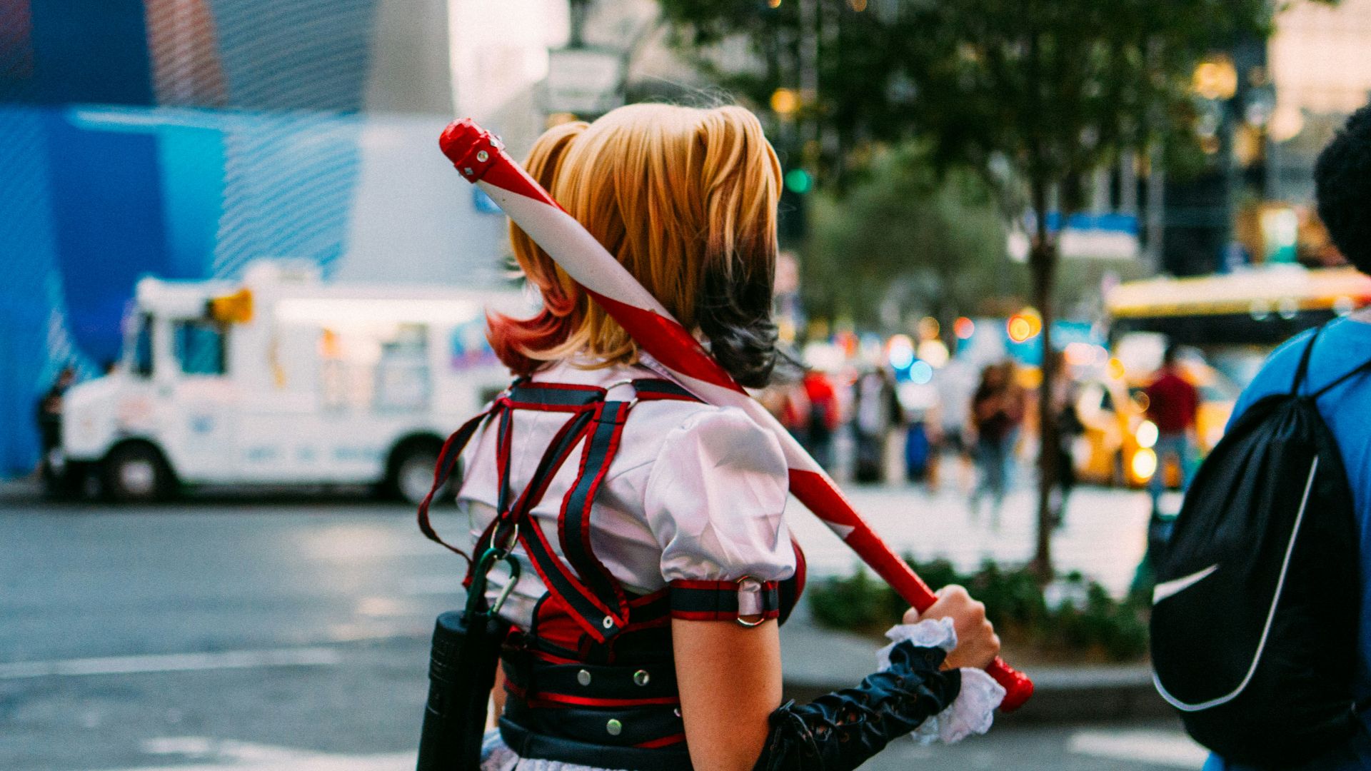woman in red and black dress walking on street during daytime