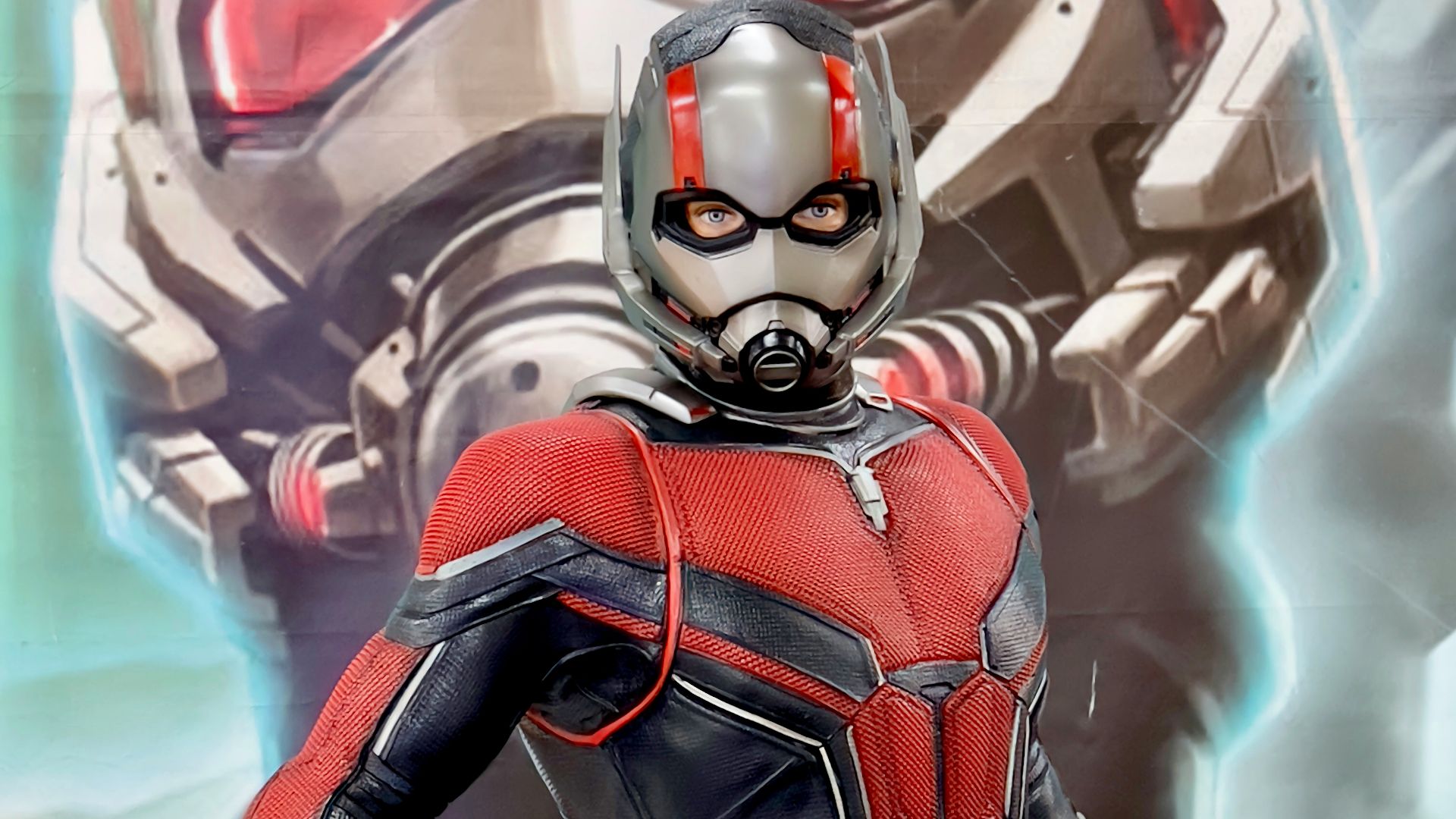 a man in a red and black suit standing next to a giant robot