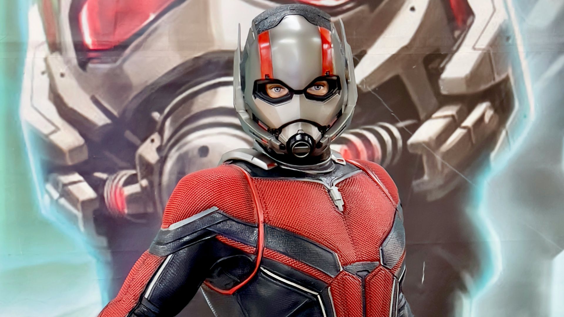 a man in a red and black suit standing next to a giant robot