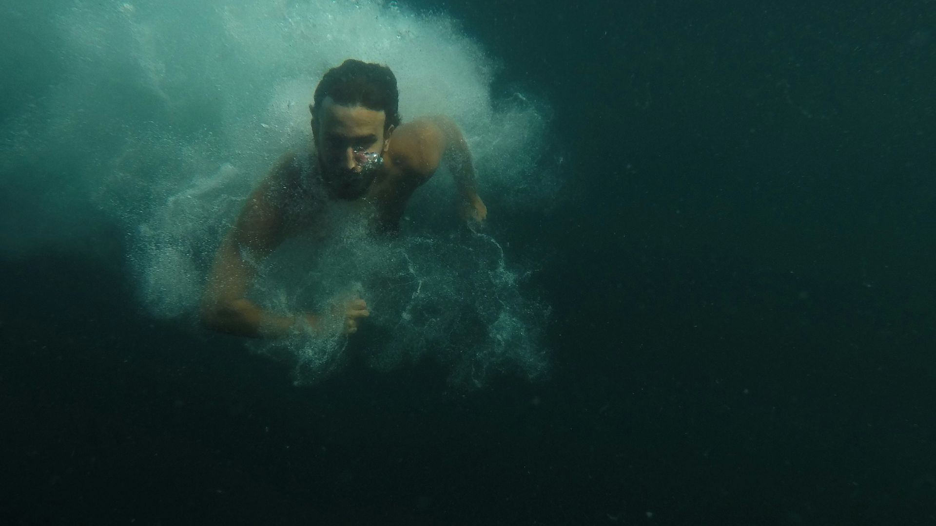 man in water with blue and white goggles