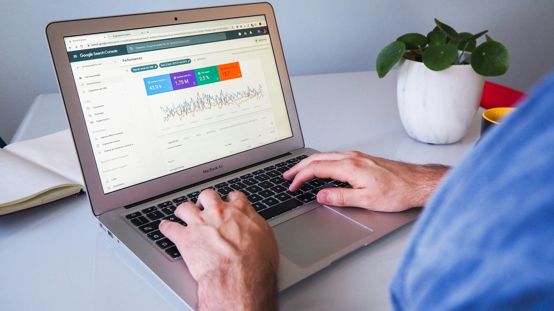 person using macbook air on white table