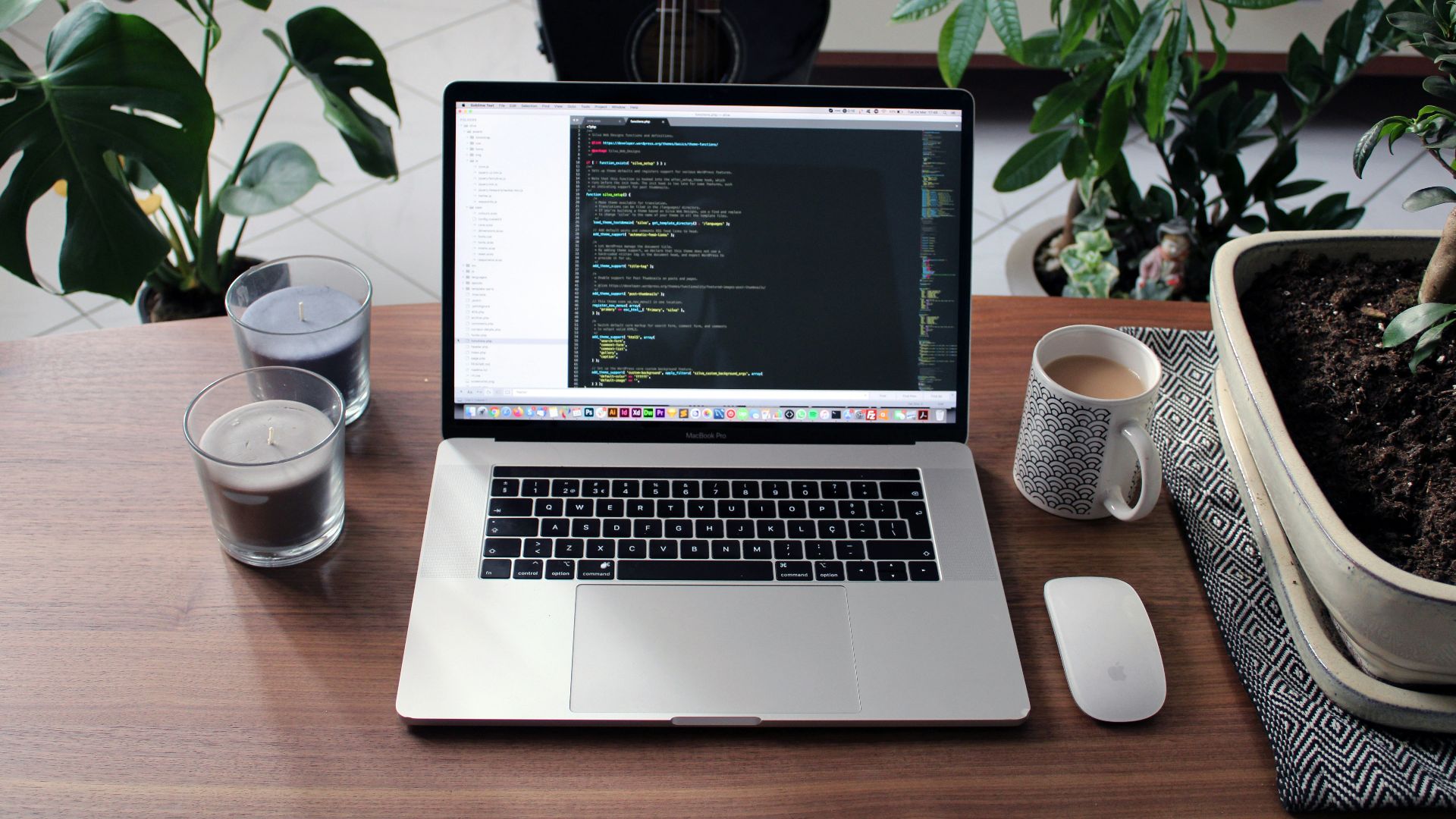 macbook pro beside white ceramic mug on brown wooden table