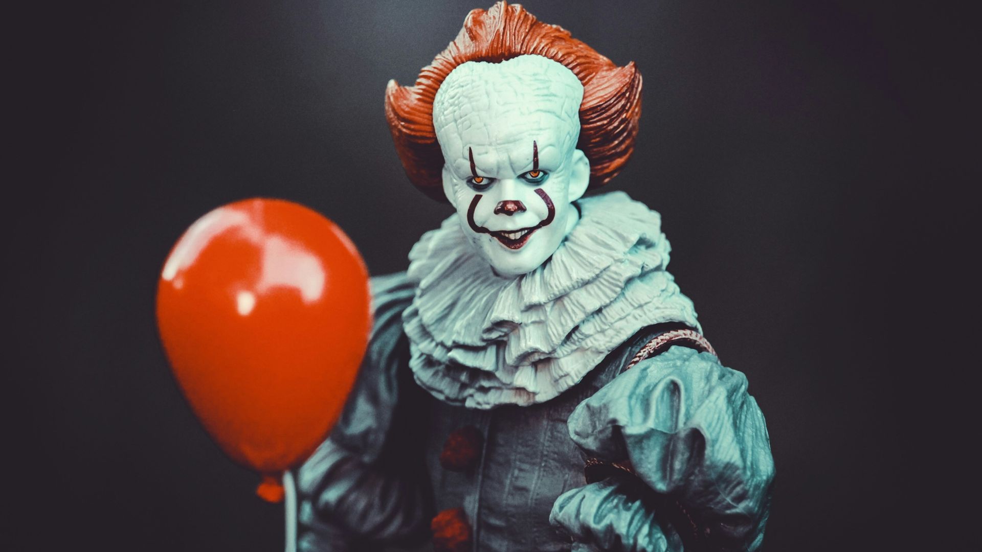 woman in blue and white dress holding red balloon