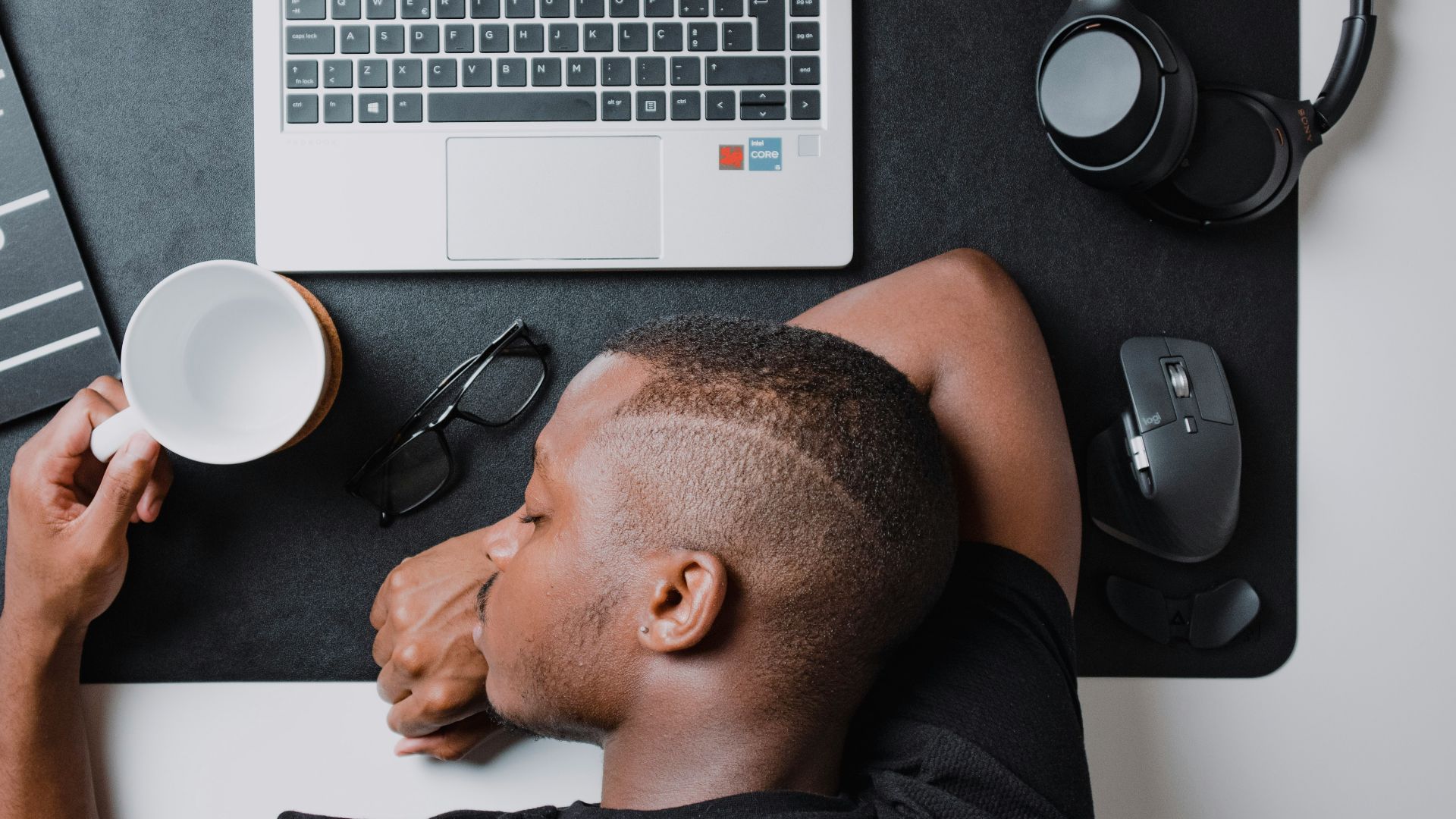 a man sitting at a desk with a laptop and headphones