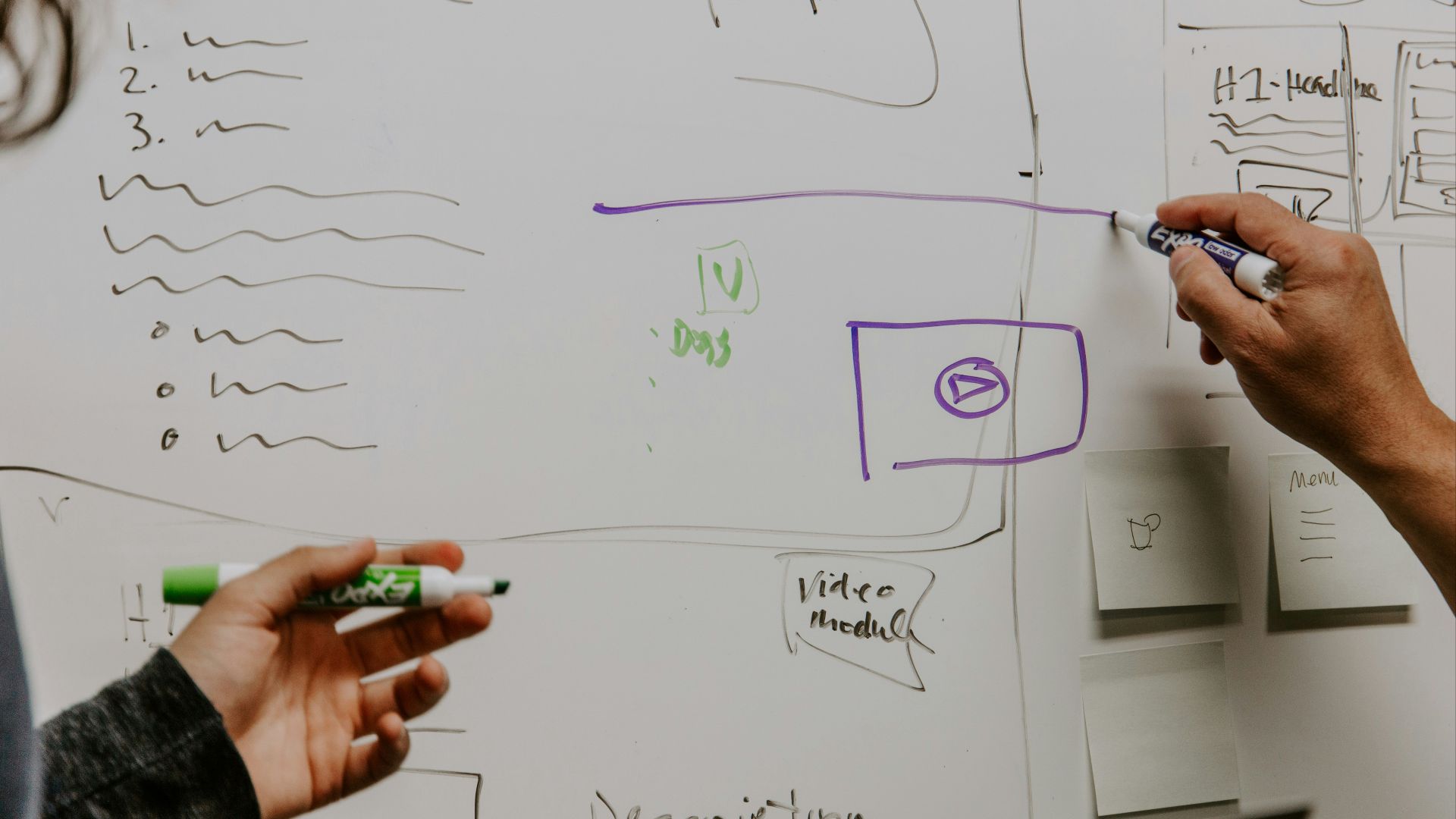 two people drawing on whiteboard