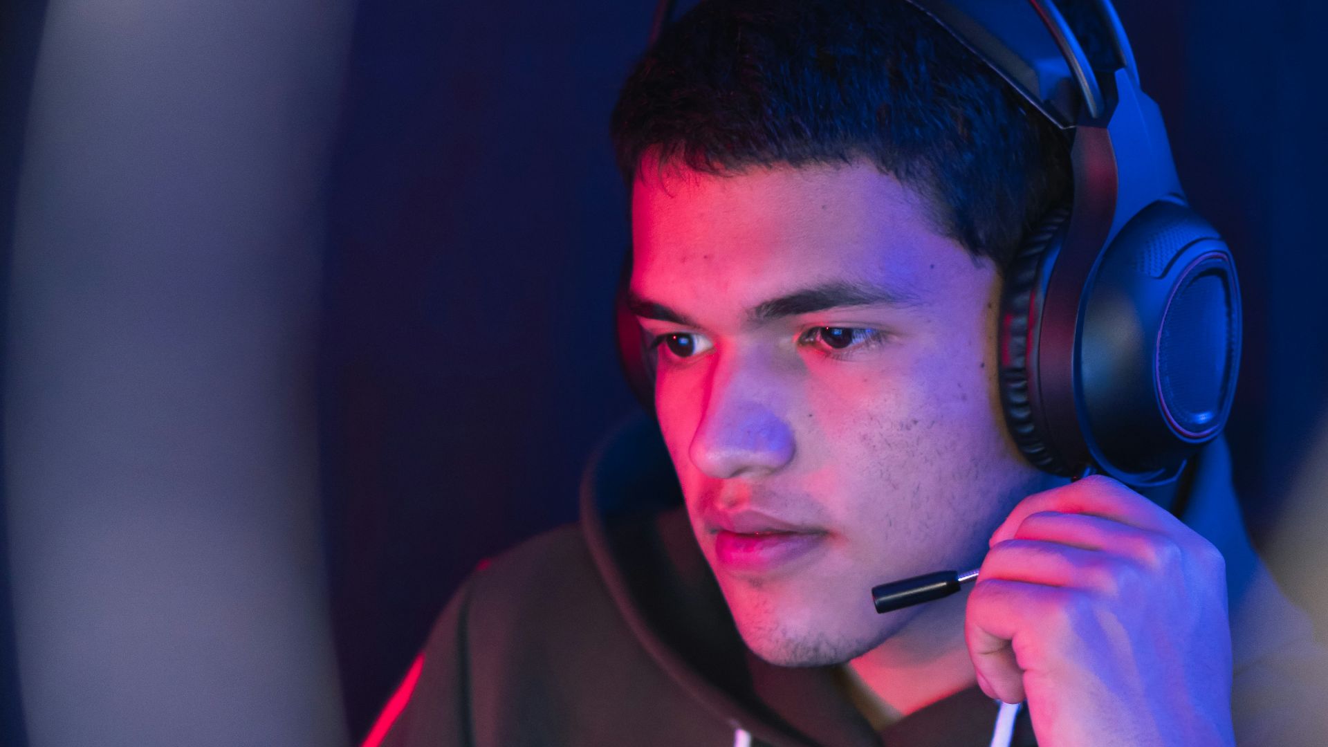 man in red hoodie wearing black headphones