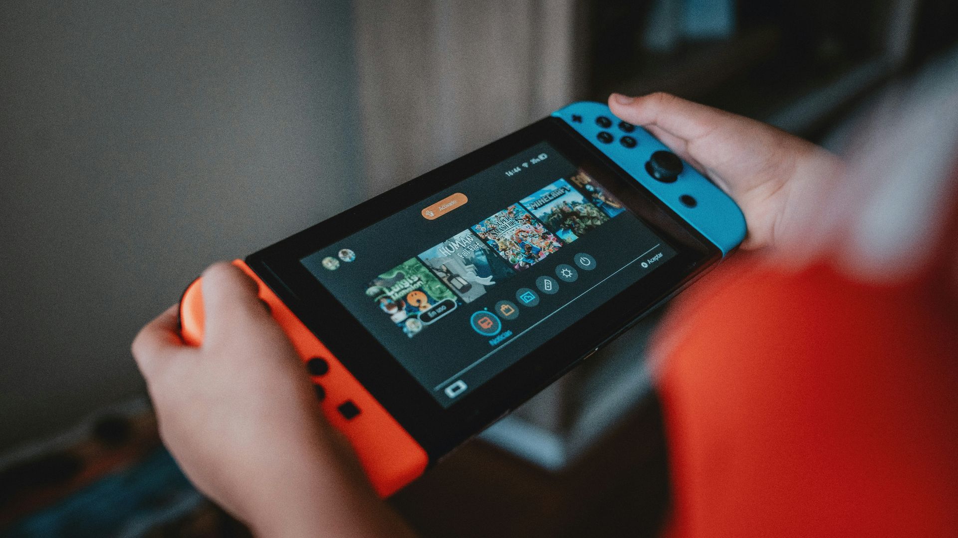 person holding black and orange nintendo switch