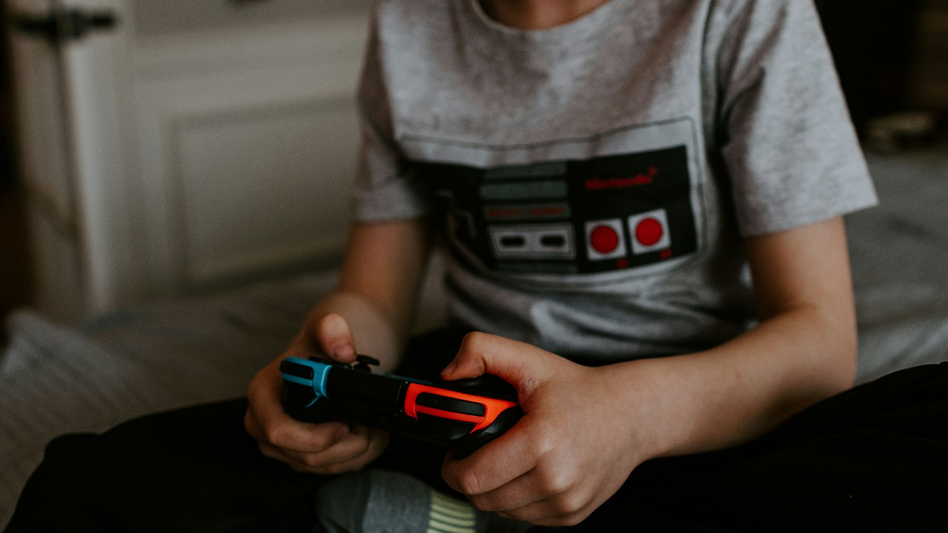 kid sitting on gray bed while playing