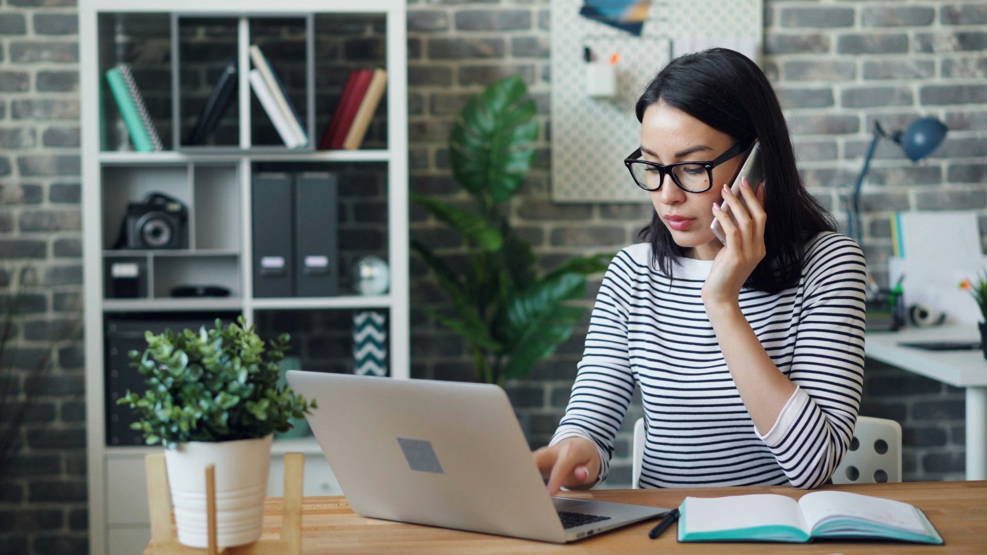 a woman sitting at a desk using a laptop computer