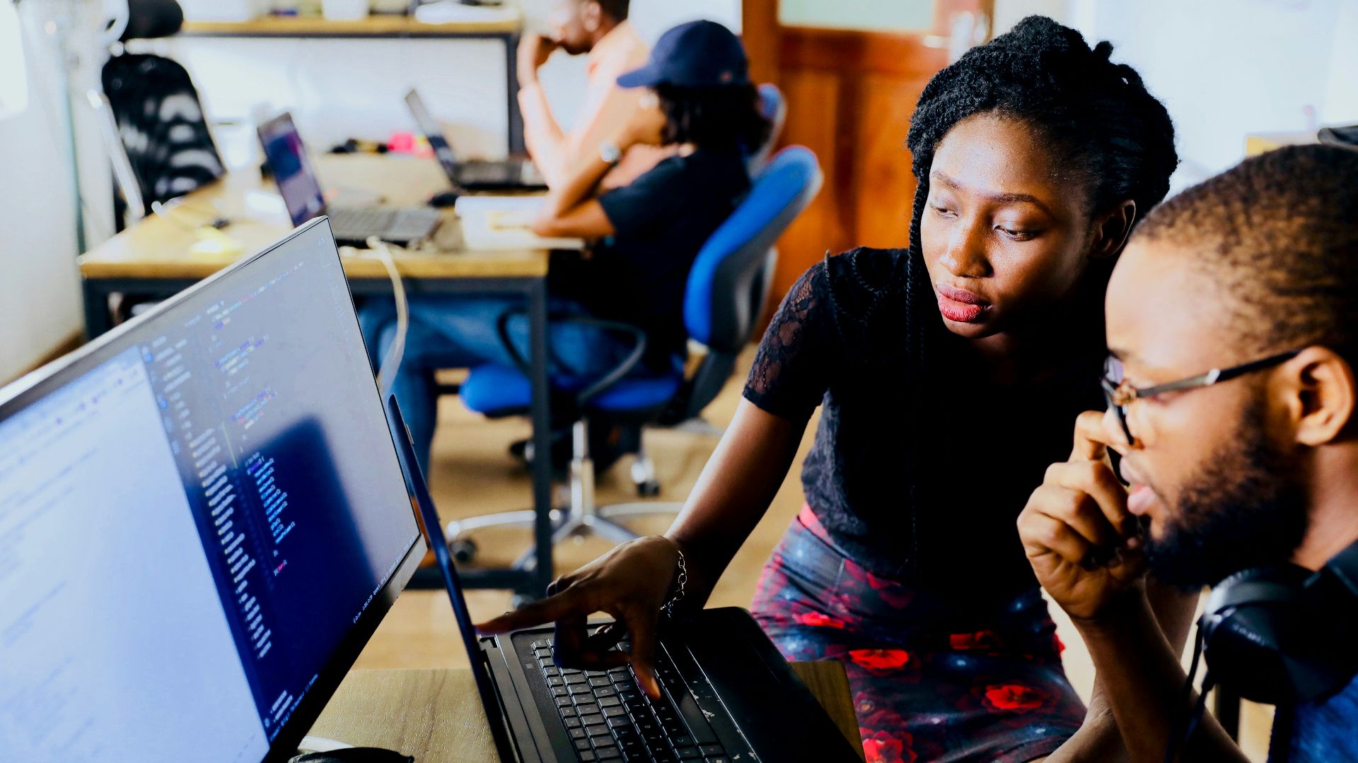 woman and man sitting in front of monitor